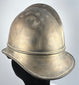 Bavarian brass firefighter helmet showing raised crown comb and aged metal patina, circa 1908–1934