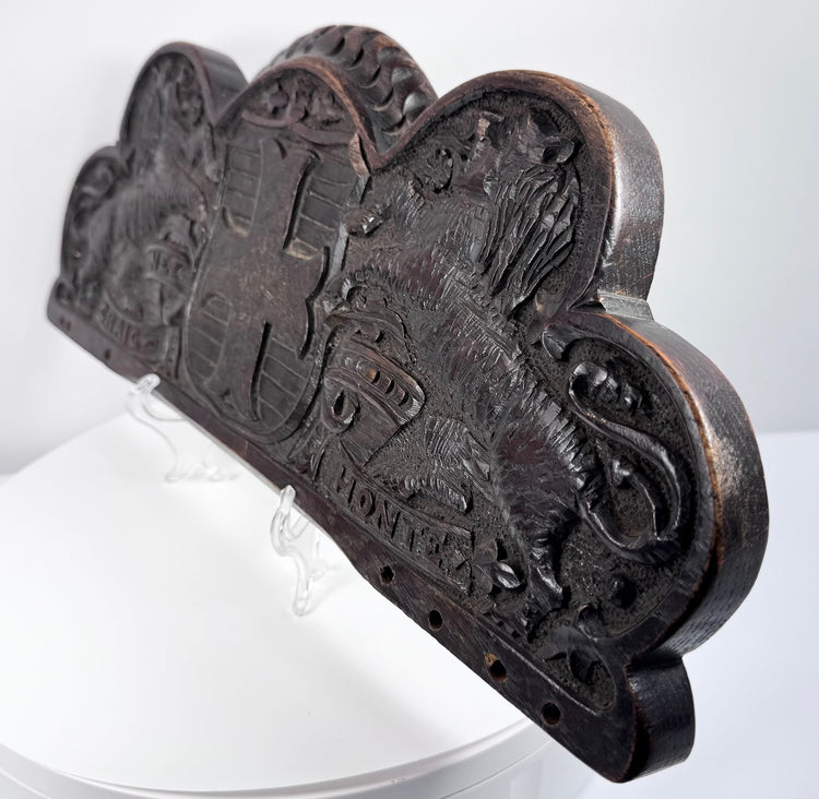 Close-up of the weathered oak surface, carved lion, heraldic shield, and naturally developed wear
