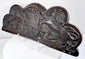 Lower edge of an antique heraldic oak cresting showing the original mounting holes and aged surface