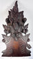 Black Forest-style carved furniture ornament showing dense botanical decoration, applied carved elements and historic surface wear