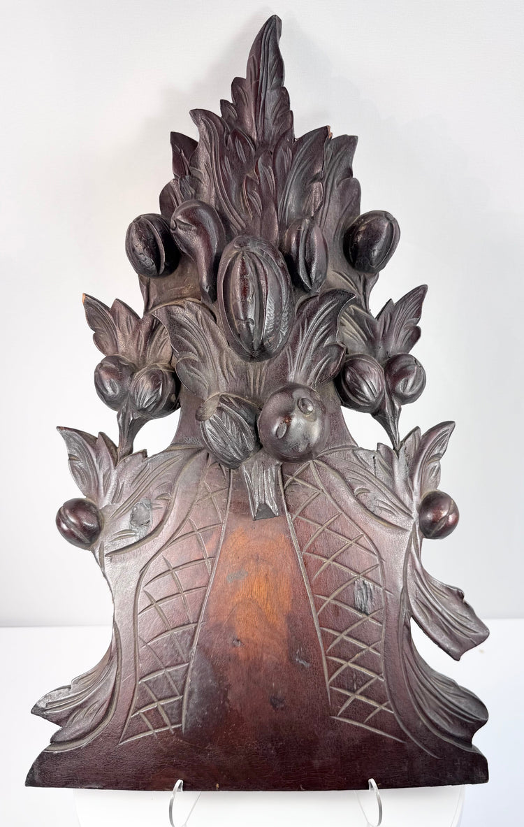 Detail of antique fruit basket carving with deeply incised crosshatching, projecting leaves and aged dark-stained wood
