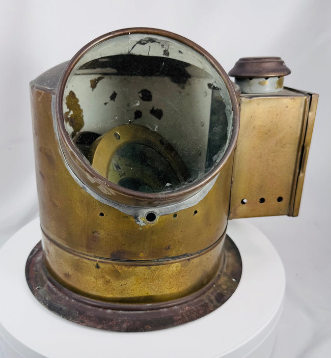 Antique shipboard navigational compass with aged brass patina and flanged mounting base