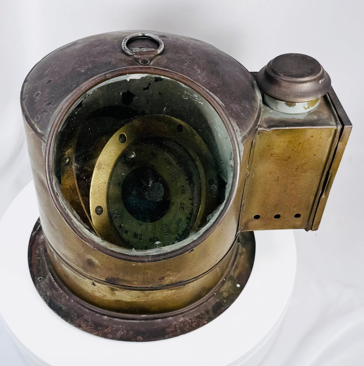 Shipboard brass binnacle compass displaying authentic maritime wear and historical character