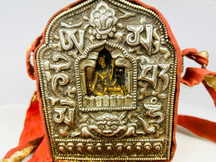 Tibetan portable Gau amulet box featuring seated Buddha and auspicious motifs, silvered copper alloy