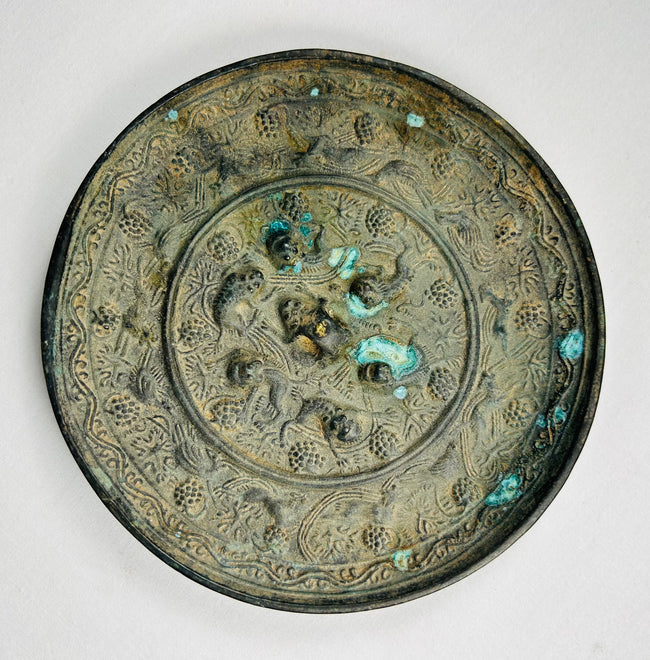 Chinese antique bronze mirror with ornate relief decoration on reverse