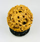 Chinese carved puzzle ball showing dragon relief work and inner rotating spheres on a black stand against a white background.
