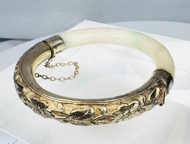 Vintage Chinese bangle with celadon-white stone, green inclusions, and silver mounts