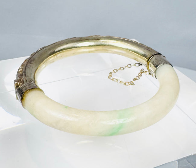 Chinese jade or hardstone bangle with chased silver mounts and aged patina