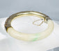 Chinese jade or hardstone bangle with chased silver mounts and aged patina