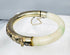 Antique Asian jewelry bracelet with pale stone segment and ornate silver floral panel