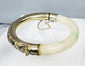 Antique Asian jewelry bracelet with pale stone segment and ornate silver floral panel