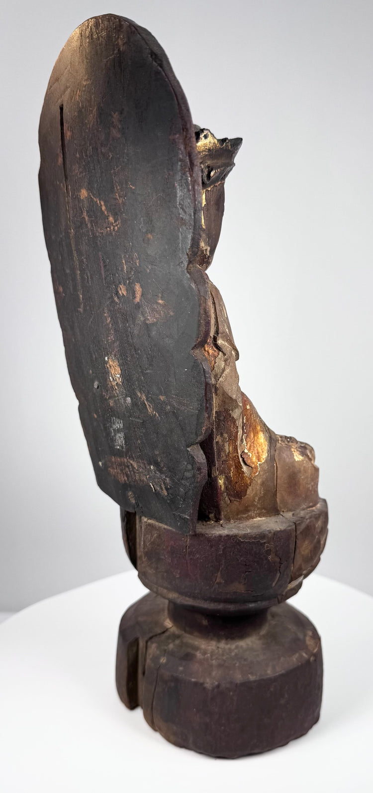 Guanyin’s folded hands in dhyana mudra surrounded by carved robe folds and surviving gold and red decoration