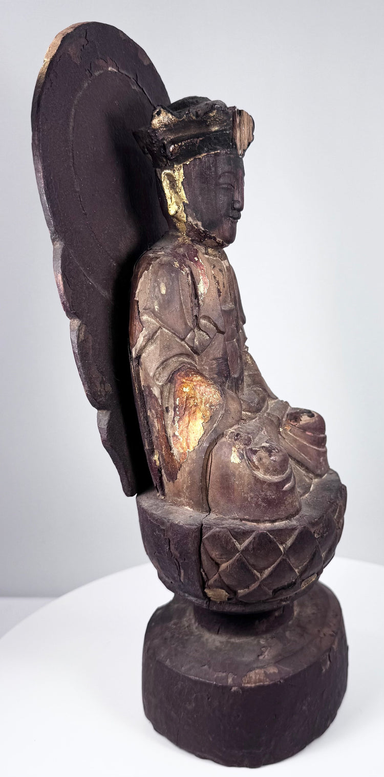 Carved lotus throne beneath antique Chinese Guanyin with overlapping petals and remnants of historic polychrome finish
