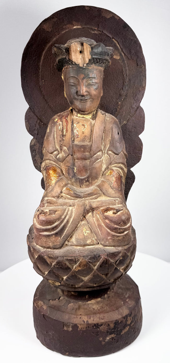 Carved wooden Guanyin with serene lowered eyes, weathered gilding and surviving elements of an elaborate crown