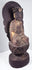 Aged circular wooden pedestal supporting the Guanyin statue with cinnabar-red pigment, cracks and historic surface losses