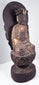 Aged circular wooden pedestal supporting the Guanyin statue with cinnabar-red pigment, cracks and historic surface losses