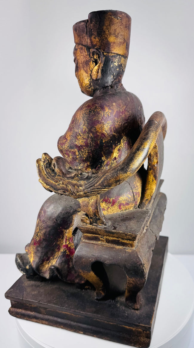 Side view of antique Chinese seated official figure showing carved throne structure, robes and stepped wooden base