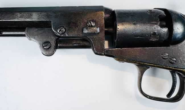Colt Model 1849 Pocket Revolver detail featuring the barrel wedge, frame screws, cylinder, and age-worn steel surfaces.