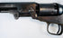 Colt Model 1849 Pocket Revolver detail featuring the barrel wedge, frame screws, cylinder, and age-worn steel surfaces.