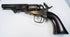 Colt Model 1849 Pocket Revolver with a smooth walnut grip, aged brass backstrap, and dark steel barrel and cylinder.