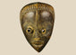 Antique Baule tribal mask from Ivory Coast, early 20th century, hand-carved wood with natural patina, oval face, almond-shaped eyes, and stylized features displayed on a stand.