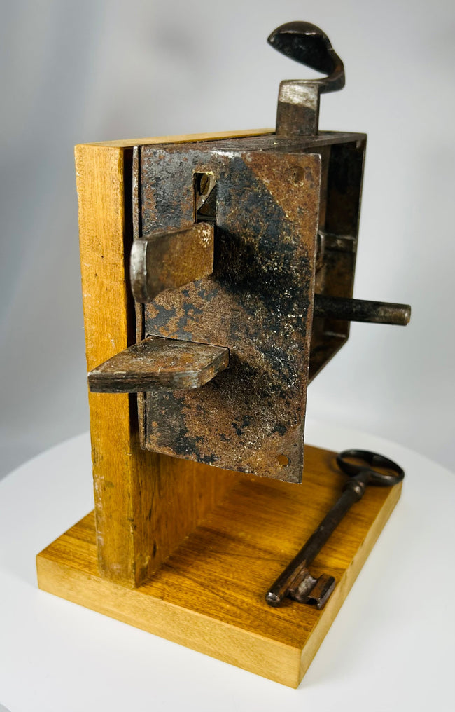 Antique security lock with exposed internal components and original iron key