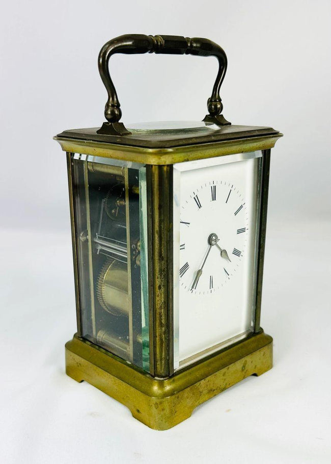 Close-up of Jules Bunelot carriage clock showing detailed brass craftsmanship and glass panels.