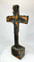 Bronze cross relic — back view on display stand revealing natural patina and form