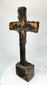 Bronze cross relic — back view on display stand revealing natural patina and form