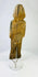 Rear view of hand-carved wooden figurine displaying age-related wear and carving details.