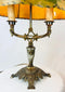 Museum-style display of a 1920s European Art Nouveau table lamp with painted parchment shade