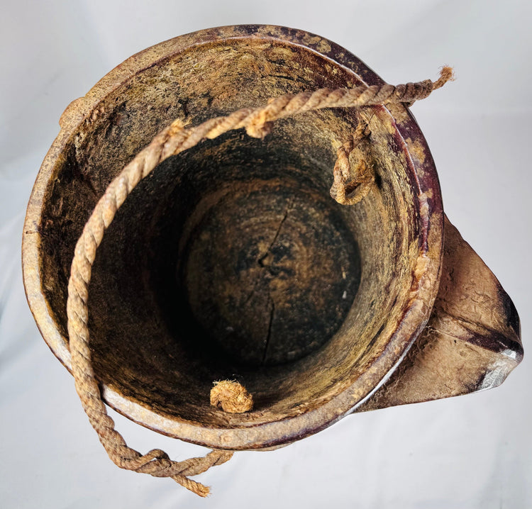 Antique carved wooden vessel with braided decorative patterns and fiber suspension loop