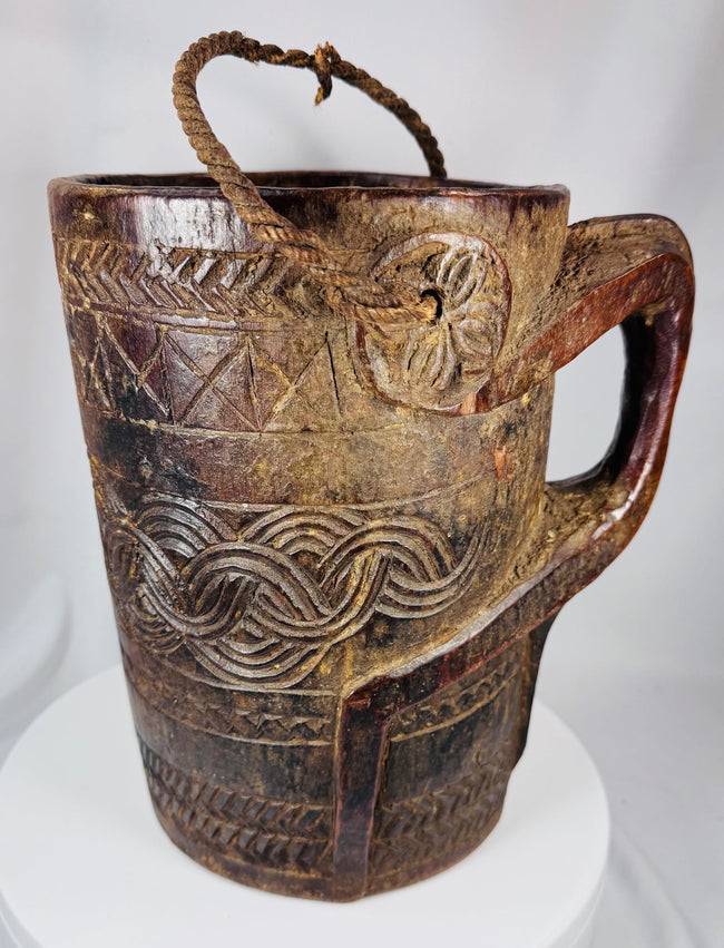 Traditional Himalayan storage vessel displaying geometric carving and rustic tribal craftsmanship