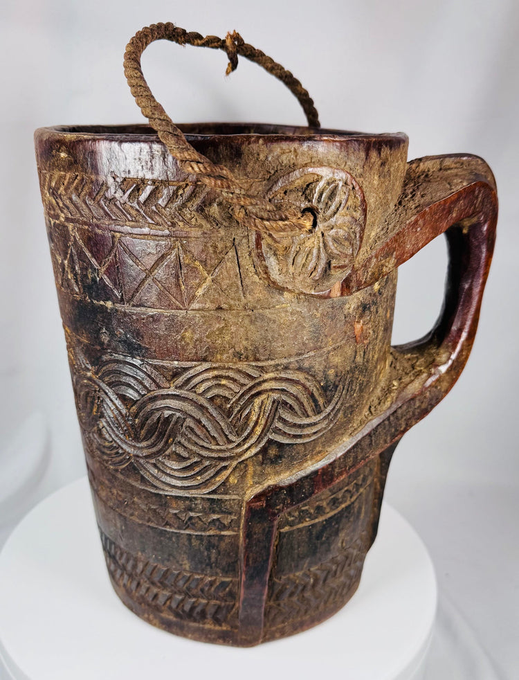 Traditional Himalayan storage vessel displaying geometric carving and rustic tribal craftsmanship