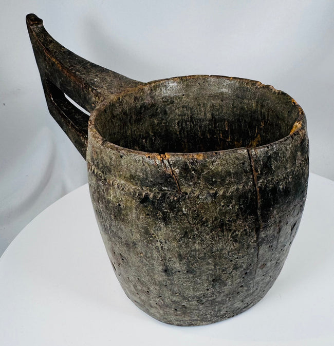 Himalayan carved hardwood vessel displaying primitive craftsmanship and decorative border motifs