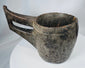 Hand-carved tribal wooden bowl with elongated handle and deep hollowed interior basin