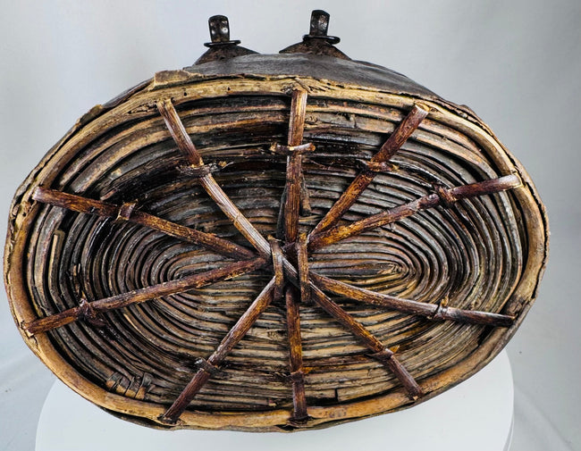 Antique Tibetan storage basket with coiled construction, iron clasps, and aged surface wear
