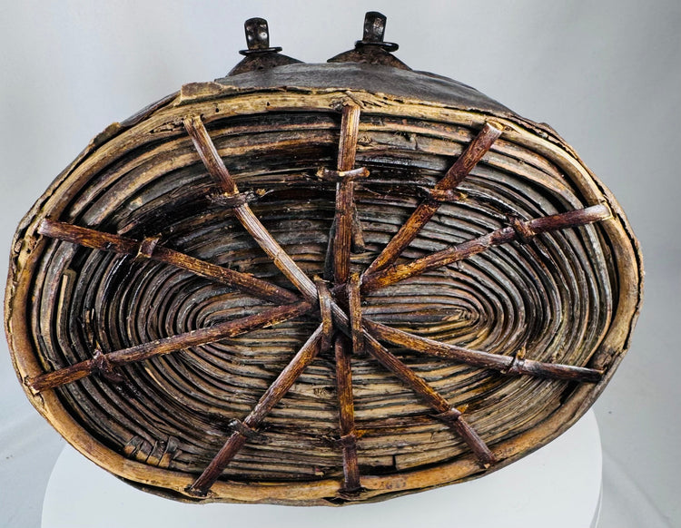 Antique Tibetan storage basket with coiled construction, iron clasps, and aged surface wear
