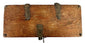 Bottom view of antique wooden strongbox displaying natural wood grain and four rounded iron foot studs