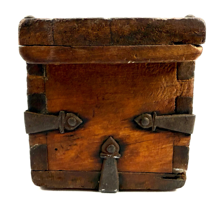 Antique Himalayan storage box with heavy hand-forged iron reinforcements, aged timber, and decorative metalwork.