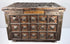 Close-up of the decorated brass lid showing dense geometric relief patterns, raised square motifs, and naturally developed patina.