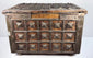 Close-up of the decorated brass lid showing dense geometric relief patterns, raised square motifs, and naturally developed patina.