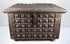 Front of a late 19th-century Indian brass-clad storage box showing repeating raised square motifs and original metal hardware.
