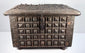 Front of a late 19th-century Indian brass-clad storage box showing repeating raised square motifs and original metal hardware.