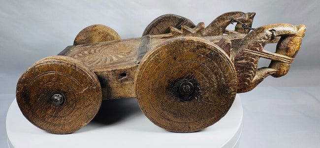 Handcrafted wooden ritual cart with carved geometric patterns and aged patina