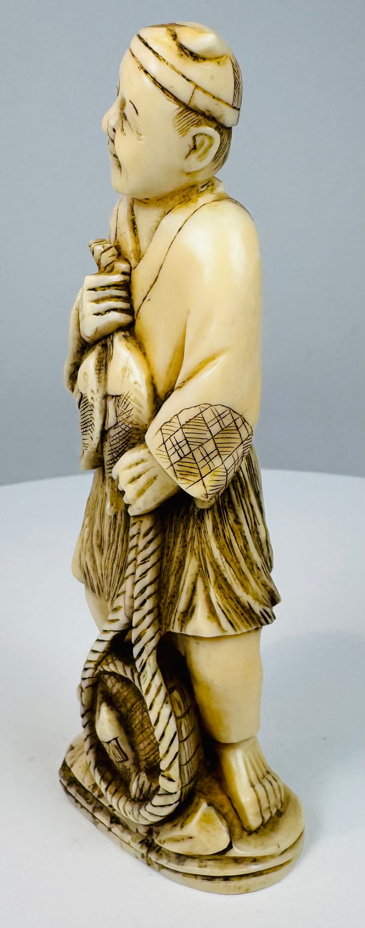 Opposite side view of the Japanese fisherman holding fish against his chest