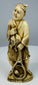 Rear three-quarter view showing the fisherman’s patterned garment and carved basket