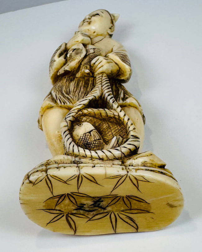 Underside of the Japanese fisherman okimono with bamboo leaves and an incised mark