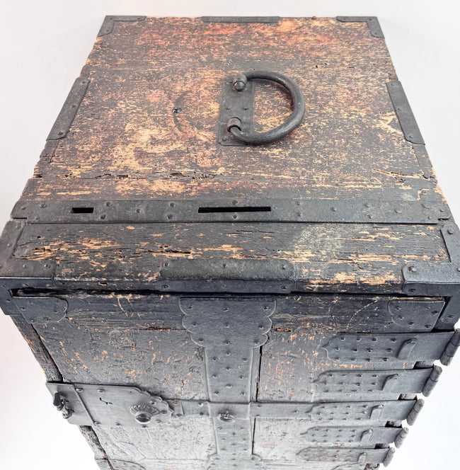 Top view of Japanese ship chest showing large iron carrying handle, deposit slots and heavily worn black finish