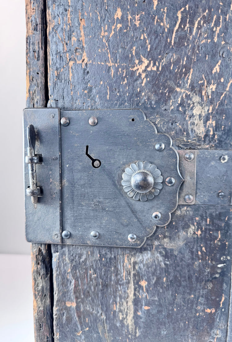 Close-up of Japanese ship chest front showing chrysanthemum-form lock fitting, riveted ironwork and hand-forged hardware